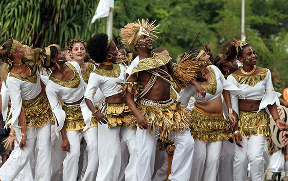 Danseurs en costume traditionnel blanc et doré pendant la parade du carnaval de Guyane