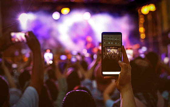 Une personne filme avec son portable la scène du festival de musique Electro de Metz