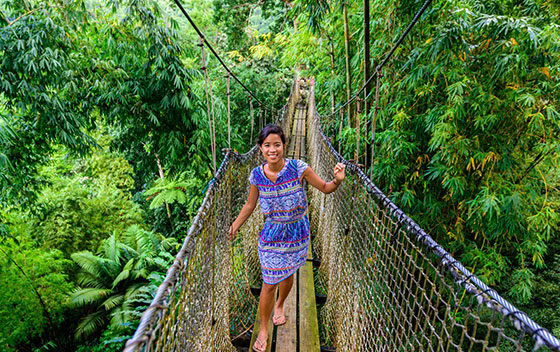 Une martiniquaise sur un pont suspendu dans le jardin botanique de Balata