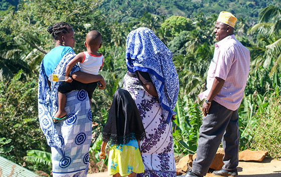 Famille mahoraise discutant devant des palmiers